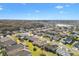 Expansive aerial view showcases a residential community with lush greenery, a tranquil lake, and well-maintained homes at 11013 Se 169Th Pl, Summerfield, FL 34491