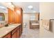 Bright bathroom featuring a soaking tub, a separate shower, and a spacious granite-topped vanity at 11013 Se 169Th Pl, Summerfield, FL 34491