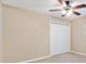 Neutral-toned bedroom featuring a ceiling fan and double door closet at 11013 Se 169Th Pl, Summerfield, FL 34491