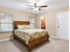 Cozy bedroom featuring a wooden bed frame, neutral walls, and a view of the serene outdoors at 11013 Se 169Th Pl, Summerfield, FL 34491
