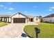 Charming single-story home with a paver driveway, well-manicured lawn, and a two-car garage at 11013 Se 169Th Pl, Summerfield, FL 34491
