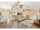 Spacious living room featuring an open layout, neutral tones, hardwood floors, and multiple ceiling fans at 11013 Se 169Th Pl, Summerfield, FL 34491
