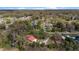 Aerial view of a home with a red roof, nestled among many mature trees in a rural area at 1300 Ne 53Rd St, Ocala, FL 34479