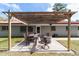 Relaxing backyard patio featuring a pergola, outdoor dining table, and fire pit, perfect for entertaining guests at 1300 Ne 53Rd St, Ocala, FL 34479