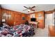 Bedroom with wood paneling walls, ceiling fan, and a red, white and blue patterned comforter at 1300 Ne 53Rd St, Ocala, FL 34479