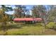 Charming brick home featuring a red roof and a large, well-maintained front lawn with mature trees at 1300 Ne 53Rd St, Ocala, FL 34479