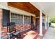 Charming front porch with rocking chairs, red brick, and white columns, creating a cozy entrance at 1300 Ne 53Rd St, Ocala, FL 34479