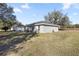 Exterior view of the backyard with trees, grass, and concrete patio at 13458 Sw 113Th Pl, Dunnellon, FL 34432