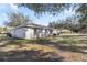 Spacious backyard featuring a well-maintained lawn and a cozy patio seating area, perfect for outdoor enjoyment at 13458 Sw 113Th Pl, Dunnellon, FL 34432