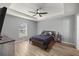 Comfortable bedroom with wood-look floors, tray ceiling, and a ceiling fan at 13458 Sw 113Th Pl, Dunnellon, FL 34432