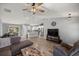 Inviting living room with wood-look floors, white walls, ceiling fan, and an open kitchen at 13458 Sw 113Th Pl, Dunnellon, FL 34432