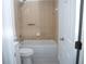 Cozy bathroom featuring a tub-shower combination, white toilet and neutral toned tiling at 13700 Sw 48Th Ct, Ocala, FL 34473