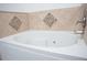 A luxurious bathtub is adorned with neutral-colored tile in the bathroom at 13700 Sw 48Th Ct, Ocala, FL 34473