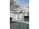 Home exterior featuring an arched entryway with decorative pillars and manicured bushes at 13700 Sw 48Th Ct, Ocala, FL 34473
