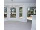Bright living room with bay window and contemporary chandelier with white walls and grey floor at 13700 Sw 48Th Ct, Ocala, FL 34473
