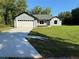 Beautiful single-story home featuring a well-maintained lawn, a long driveway, and an attached two-car garage at 14 Bay Terrace Pass, Ocklawaha, FL 32179