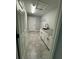 Convenient laundry room with a sink, white cabinets, granite countertops, and gray tile flooring at 14 Bay Terrace Pass, Ocklawaha, FL 32179