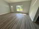 Bright living room with luxury vinyl plank flooring, neutral paint, and a large window at 14 Bay Terrace Pass, Ocklawaha, FL 32179