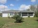 View of the back of the home with a screened-in porch and a well maintained lawn at 15756 Sw 37Th Cir, Ocala, FL 34473