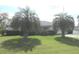 Well-manicured front yard featuring lush green grass and mature palm trees enhancing curb appeal at 15756 Sw 37Th Cir, Ocala, FL 34473