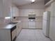 Bright kitchen featuring white appliances, ample counter space, and tile flooring at 15756 Sw 37Th Cir, Ocala, FL 34473