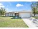 Charming single-story home with a two-car garage, well-maintained lawn, and inviting facade at 159 Water Trak, Ocala, FL 34472