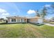 Inviting home with a spacious front yard and a long driveway leading to a two-car garage at 159 Water Trak, Ocala, FL 34472