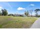 Spacious front yard view of this home with a long driveway leading to a two-car garage at 159 Water Trak, Ocala, FL 34472