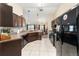 Spacious kitchen with dark wood cabinets, black appliances, and tiled floors at 159 Water Trak, Ocala, FL 34472