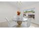 Dining room boasts a glass-top table with white chairs, tile flooring, and a bright window view at 17 Pine Course Loop, Ocala, FL 34472