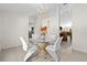 Bright dining room with a glass table, white chairs, and tile flooring, open to the kitchen at 17 Pine Course Loop, Ocala, FL 34472