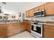 Well-lit kitchen features modern appliances, tile flooring, and light wood cabinets for a warm and inviting space at 17 Pine Course Loop, Ocala, FL 34472