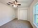 Neutral bedroom with a ceiling fan, double-door closet, and a sunlit window overlooking the outdoors at 17710 Sw 48Th Pl, Dunnellon, FL 34432