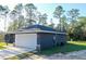 Single-story house with a two-car garage, a well-kept lawn, and surrounded by lush greenery at 17710 Sw 48Th Pl, Dunnellon, FL 34432