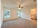 Spacious bedroom with natural light, neutral carpet, ceiling fan, and ensuite bathroom at 17710 Sw 48Th Pl, Dunnellon, FL 34432