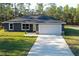 Charming single-story home featuring a two-car garage, well-manicured lawn, and inviting neutral paint scheme at 17710 Sw 48Th Pl, Dunnellon, FL 34432