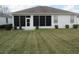 Spacious backyard with lush green grass, manicured shrubbery, and a screened-in patio at 2459 Nw 55Th Avenue Rd, Ocala, FL 34482
