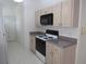 Well-lit kitchen featuring wood cabinets and black appliances, with a vinyl floor at 2459 Nw 55Th Avenue Rd, Ocala, FL 34482