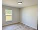 Sun-filled bedroom featuring wood-look vinyl floors and a window view at 31 Juniper Pass Ln, Ocala, FL 34480