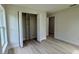 Bedroom featuring wood-look floors and a closet with built-in shelving for organization at 31 Juniper Pass Ln, Ocala, FL 34480