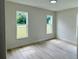 Bright bedroom with wood-look floors and dual windows offering ample natural light at 31 Juniper Pass Ln, Ocala, FL 34480