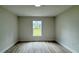 Bright bedroom featuring new hard surface flooring, a window, and neutral paint at 31 Juniper Pass Ln, Ocala, FL 34480