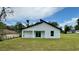Modern home exterior with unique roof line, new lawn, and sliding glass door at 31 Juniper Pass Ln, Ocala, FL 34480