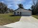 Well-kept single-story home features fresh exterior and a spacious concrete driveway at 31 Juniper Pass Ln, Ocala, FL 34480