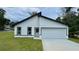 Charming single-story home with a modern design, black trim, white siding, and an attached garage at 31 Juniper Pass Ln, Ocala, FL 34480
