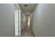 Long hallway with wood-look flooring and neutral walls, leading to other areas of the home at 31 Juniper Pass Ln, Ocala, FL 34480
