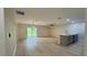 Open-concept living room with kitchen island, wood-look floors, and sliding glass doors to the backyard at 31 Juniper Pass Ln, Ocala, FL 34480