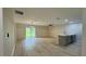 Open-concept living room with kitchen island, wood-look floors, and sliding glass doors to the backyard at 31 Juniper Pass Ln, Ocala, FL 34480