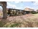 Home's backyard features mulched landscape, large tree, and glass enclosed patio at 3447 Sw 19Th Pl, Ocala, FL 34474