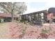 Home's backyard featuring glass enclosed patio, mulched flower beds, and large trees at 3447 Sw 19Th Pl, Ocala, FL 34474